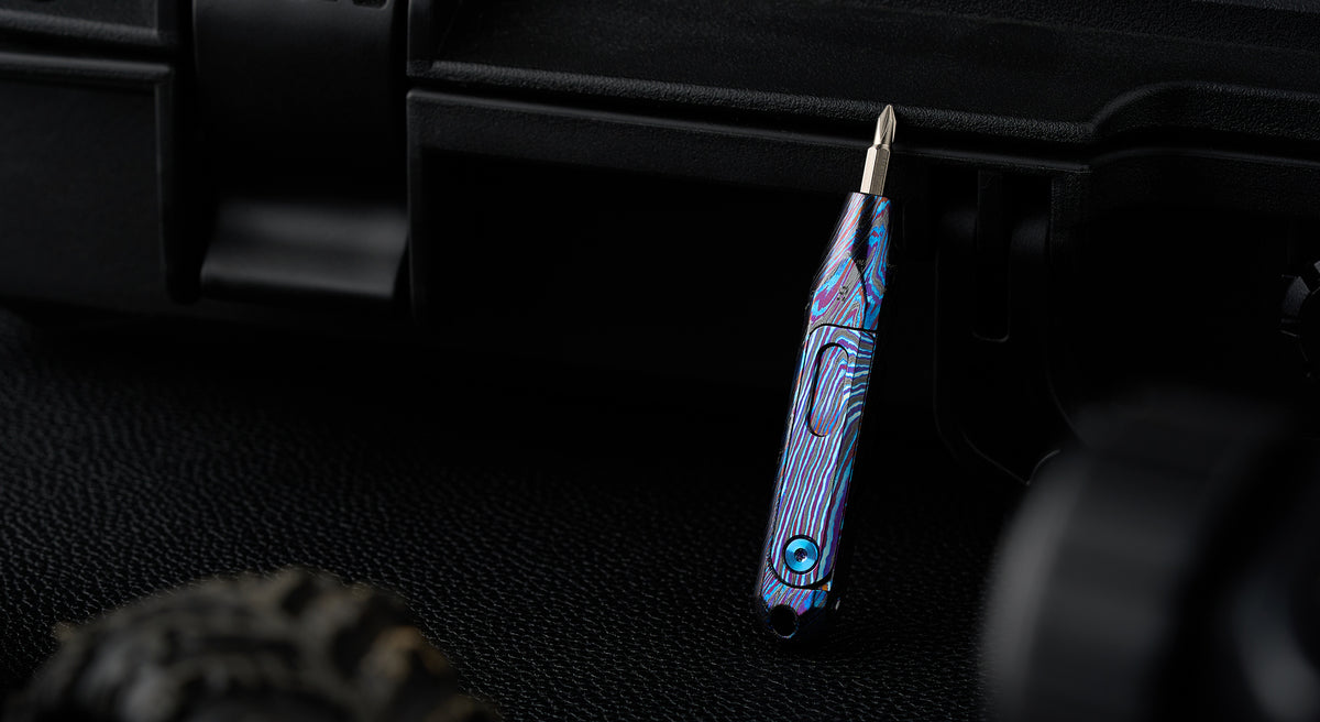 D1 zirconium damascus screwdriver standing against a dark textured background